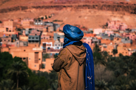 Touareg looking at the city, blue vest, adventurous journey in Morocco