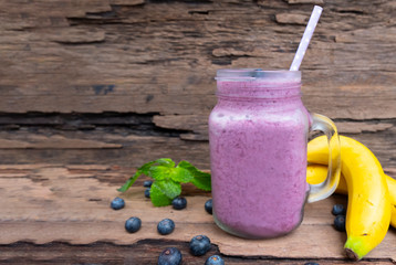 Blueberry juice and Banana smoothies a tasty healthy drink in a glass drink the morning on a wooden background.