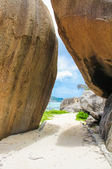 Exotic turquoise lagoon between large smooth rocks in the Seychelles