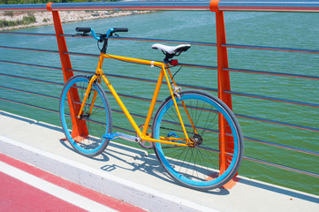Fototapeta na wymiar Yellow fixed gear bicycle on a bridge