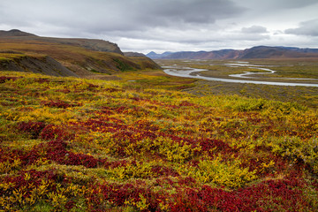 Autumn tundra. Scenic valley of the river among the mountains. The beginning of the fall season in...