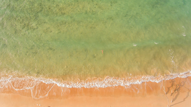 Aerial veiw of a beach with a girl floating in Tioman island, Malaysia, Asia.
