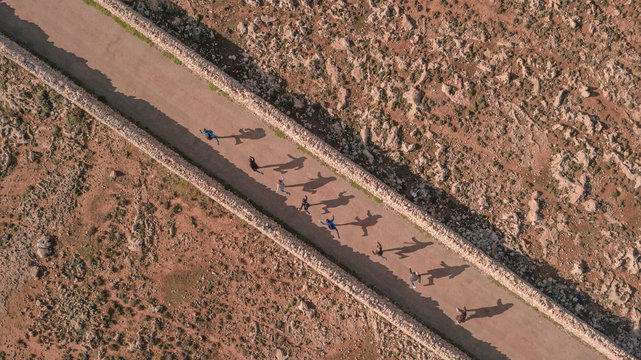 Aerial view of people and their shadows in Menorca, Balearic Islands, Spain.