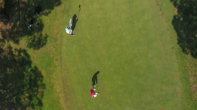 Aerial view of golf players and their shadows in Lloret, Catalonia, Spain.