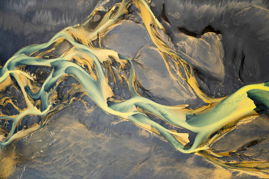 Aerial view of a volcanic river just outside of Villingholt, Iceland. Rivers like this are all over the Icelandic landscape, with colors ranging from yellow to blue to green.