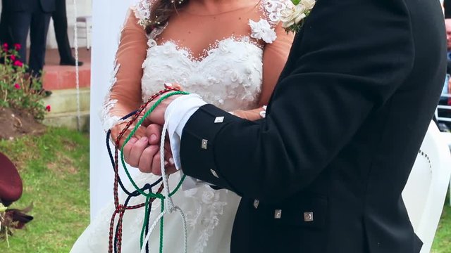 Wedding ceremony hands tied in nautical rope handfasting vows