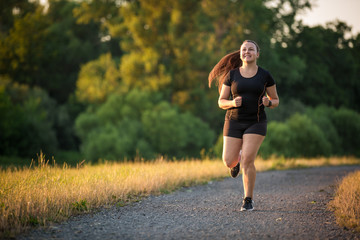 Young woman running outdoors on a lovely sunny summer evening, running concept