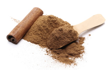 Cinnamon stick with ground powder and wooden spoon isolated on white background