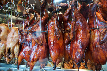 SAN FRANCISCO, CALIFORNIA, UNITED STATES - NOV 25th, 2018: Full body roast duck in city food market, Chinese restaurant, whole duck carcasses hanging on hooks while cooking in the oven