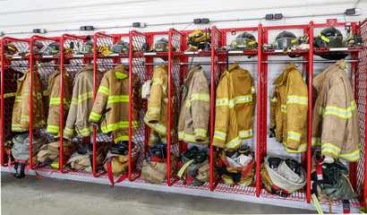 A horizontal photo of firemen uniforms hanging in there locker.