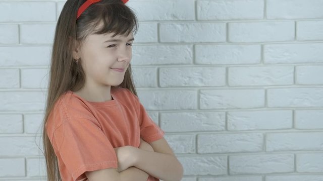 A child with horns for Halloween. A cunning little girl in the horns of the devil.