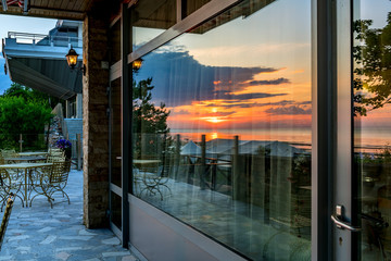 Sunrise with reflections of seascape in shop glass window,  morning in European tourist resort