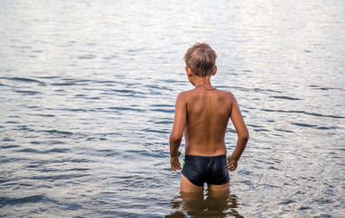 a boy of seven years is swimming in the river