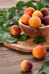 ripe apricots in a wooden bowl on the background of not painted boards