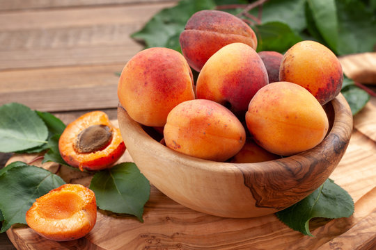 ripe apricots in a wooden bowl on the background of not painted boards