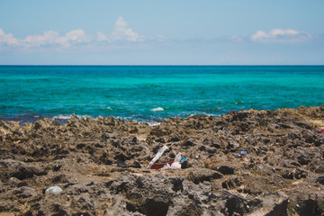 Fototapeta na wymiar COZUMEL, Mexico: trash on the beach, turquoise horizon sea on the background 