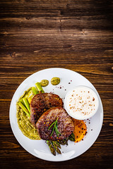 Grilled steak with asparagus on wooden background