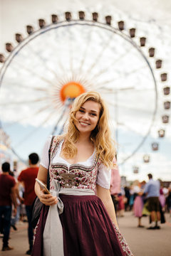 Young blond woman standing in front of Feriss wheel