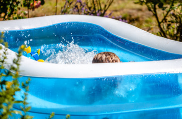 Young boy drowning in the swimming pool in the summer