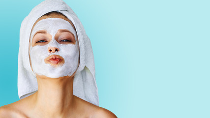 Beautiful young woman with facial mask on her face. Skin care and treatment, spa, natural beauty...