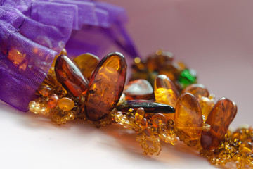 Amber, women's jewelry made of natural stone Amber on a light background pours from a decorative...