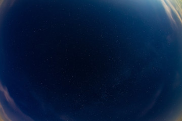 Extra wide angle of night sky with clouds and slightly visible milky way