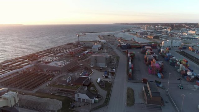 Aerial view of container terminal. Drone shot flying over harbor and stacked intermodal containers at sunset. Helsingborg, Sweden