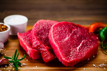 Fresh raw beef steaks on cutting board