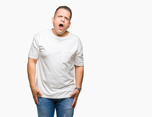 Middle age arab man wearig white t-shirt over isolated background In shock face, looking skeptical and sarcastic, surprised with open mouth