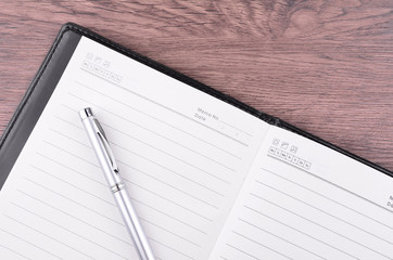 Pen and notepad on wooden table