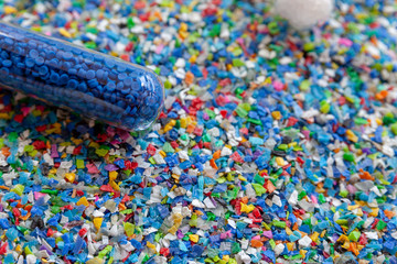 Crushed plastic granules for recycling.  Plastic crusher. Recycled plastic with mixed colors. The...
