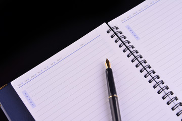 Notebook with fountain pen on wooden table