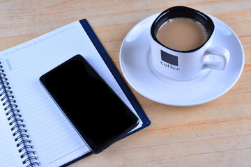 Fototapeta na wymiar Blank Notebook, fountain pen, smartphone and cup of coffee on work desk