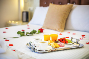 Desayuno saludable con cafe y zumo de naranja y fresas en la cama del hotel 