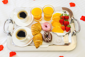 Desayuno saludable con cafe y zumo de naranja y fresas en la cama del hotel 