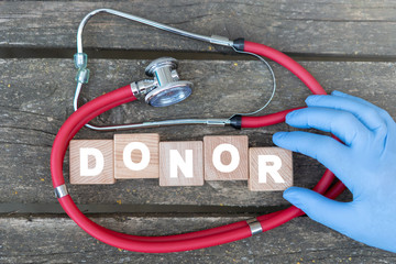 Donor blood and organs donation medical concept on wooden cubes, stethoscope and doctor's hand...