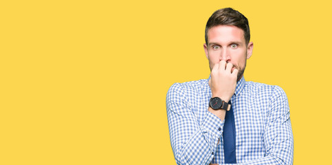 Handsome business man wearing tie looking stressed and nervous with hands on mouth biting nails. Anxiety problem.