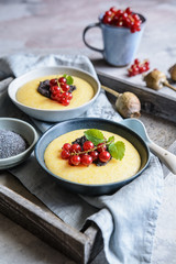 Sweet cornmeal porridge, topped with poppy seeds and currant