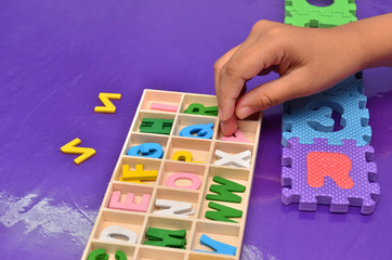 Fototapeta premium Child's hands playing with alphabet