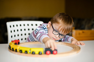little ginger boy with glasses with syndrome dawn playing