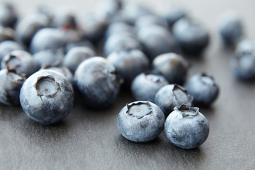 bunch of blueberry berries close-up on a dark stone background, strong blur background