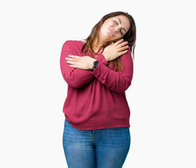 Beautiful plus size young woman over isolated background Hugging oneself happy and positive,...