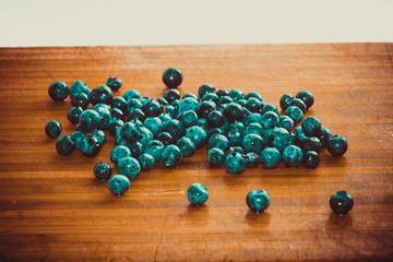 Black blueberries scattered on a wooden Board