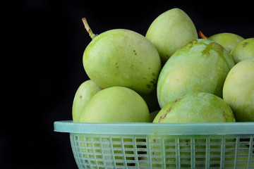 Fresh green mango in basket over black background