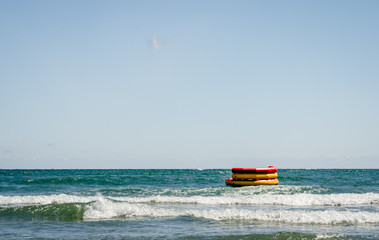 Round colorful nflatable boat ready for fun  on water  near sheashore .