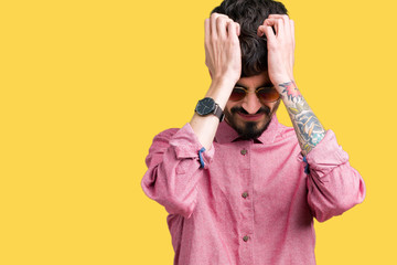 Young handsome man wearing sunglasses over isolated background suffering from headache desperate and stressed because pain and migraine. Hands on head.