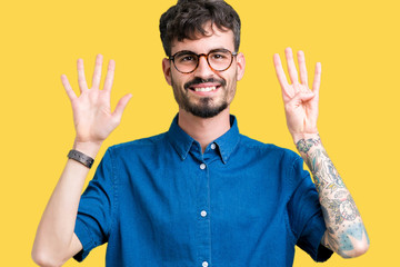 Young handsome man wearing glasses over isolated background showing and pointing up with fingers...