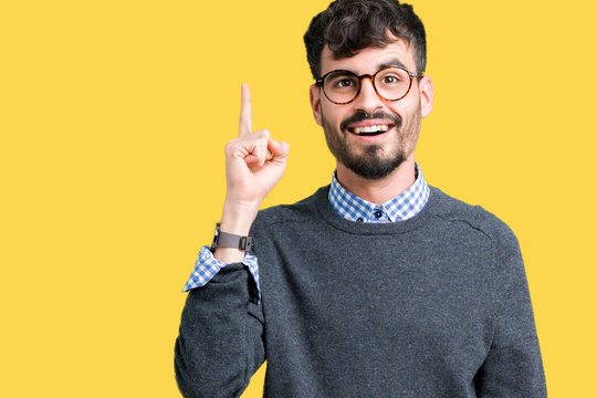 Young handsome smart man wearing glasses over isolated background pointing finger up with successful idea. Exited and happy. Number one.