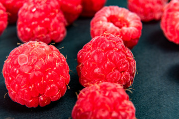 Fresh organic raspberries background closeup. Fresh raspberries on black background
