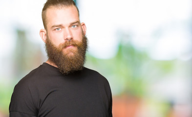 Young blond man wearing casual t-shirt Relaxed with serious expression on face. Simple and natural looking at the camera.